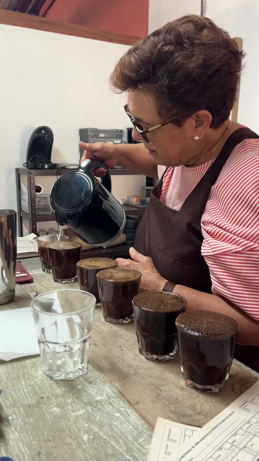 Pouring water into tasting glasses during a coffee cupping session